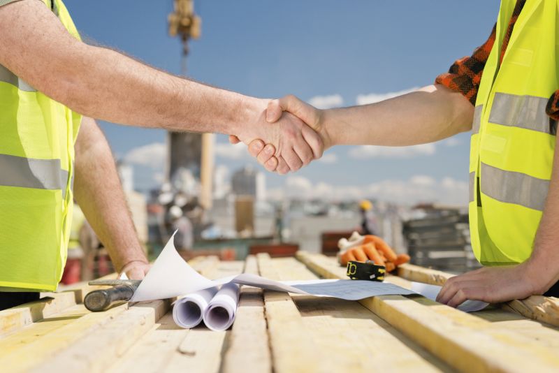 Construction workers shaking hands on construction